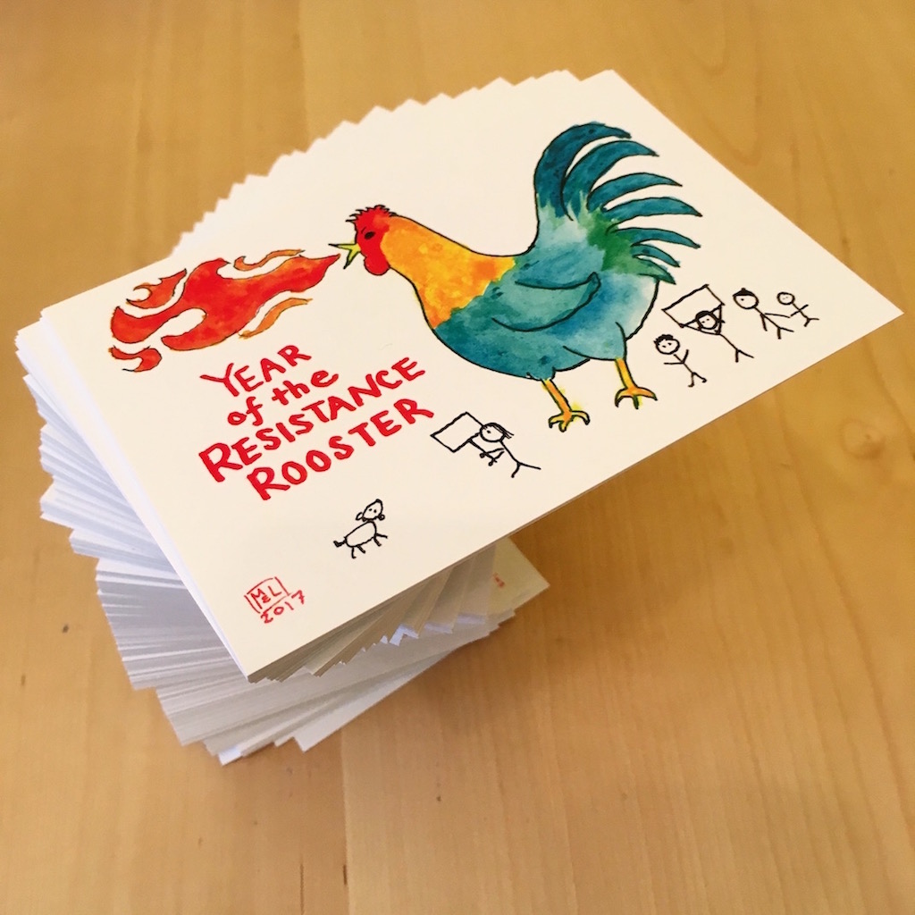A stack of postcards with a drawing of a giant rooster and protesters. The text reads "Year of the Resistance Rooster."