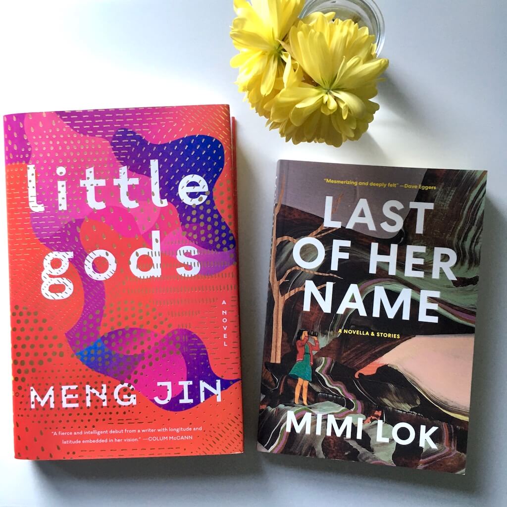 KSW Presents: Meng Jin and Mimi Lok. The books Little Gods by Meng Jin and Last of Her Name by Mimi Lok on a white surface. There are small yellow flowers in a clear bud vase.